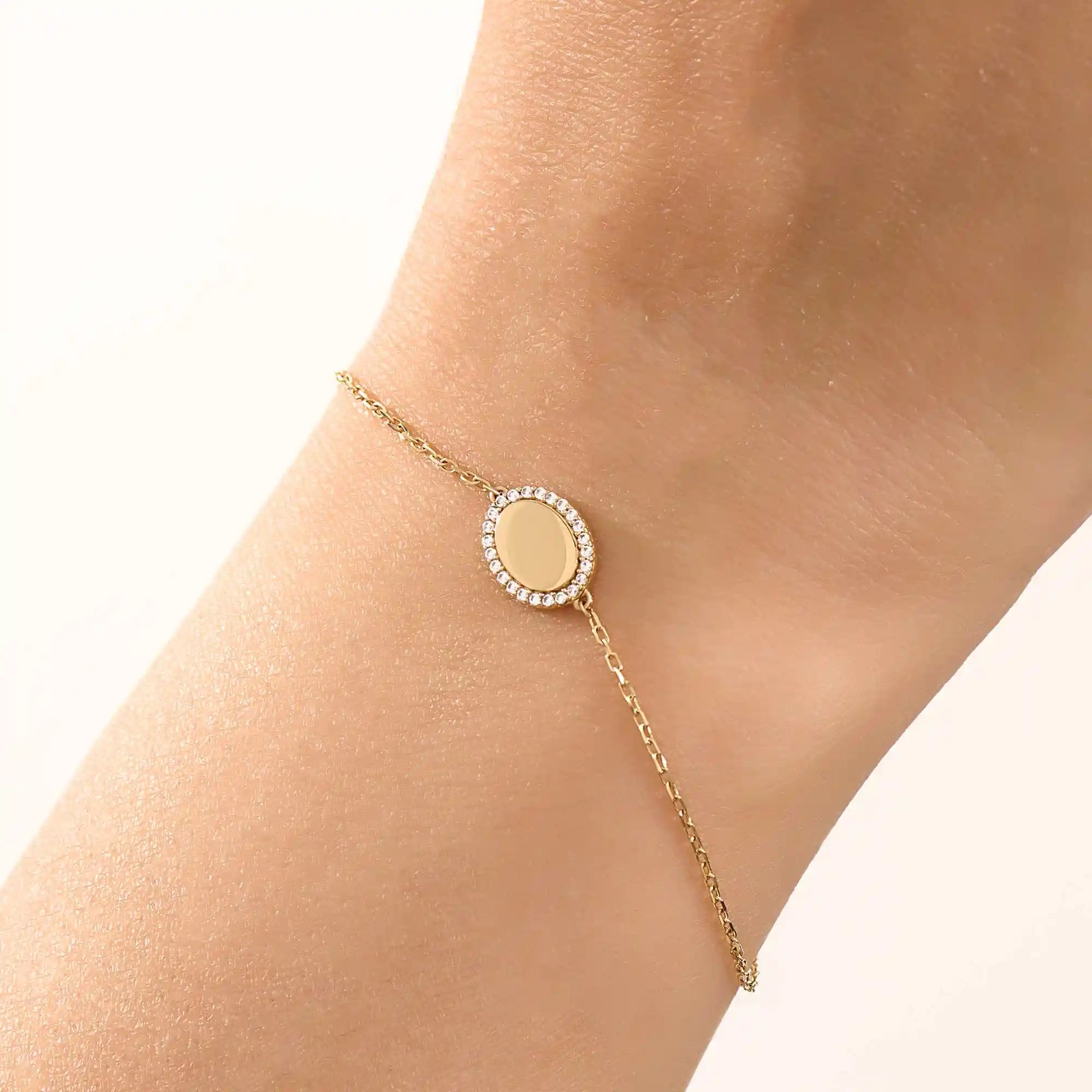 Model wearing a 14k yellow gold oval bracelet with pavé moissanite halo, adding refined sparkle to the wrist.