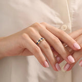 Model wearing a 5-stone oval sapphire ring in 14k gold. Eye-catching gemstone statement ring with modern bezel settings.