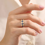 Model wearing a 5-stone oval sapphire ring in 14k gold. Eye-catching gemstone statement ring with modern bezel settings.