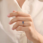 Model wearing a 5 pear sapphire gold ring on hand. Classic anniversary ring with vivid blue sapphires in 14k solid gold.