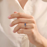 Model wearing a 5 pear sapphire gold ring on hand. Classic anniversary ring with vivid blue sapphires in 14k solid gold.