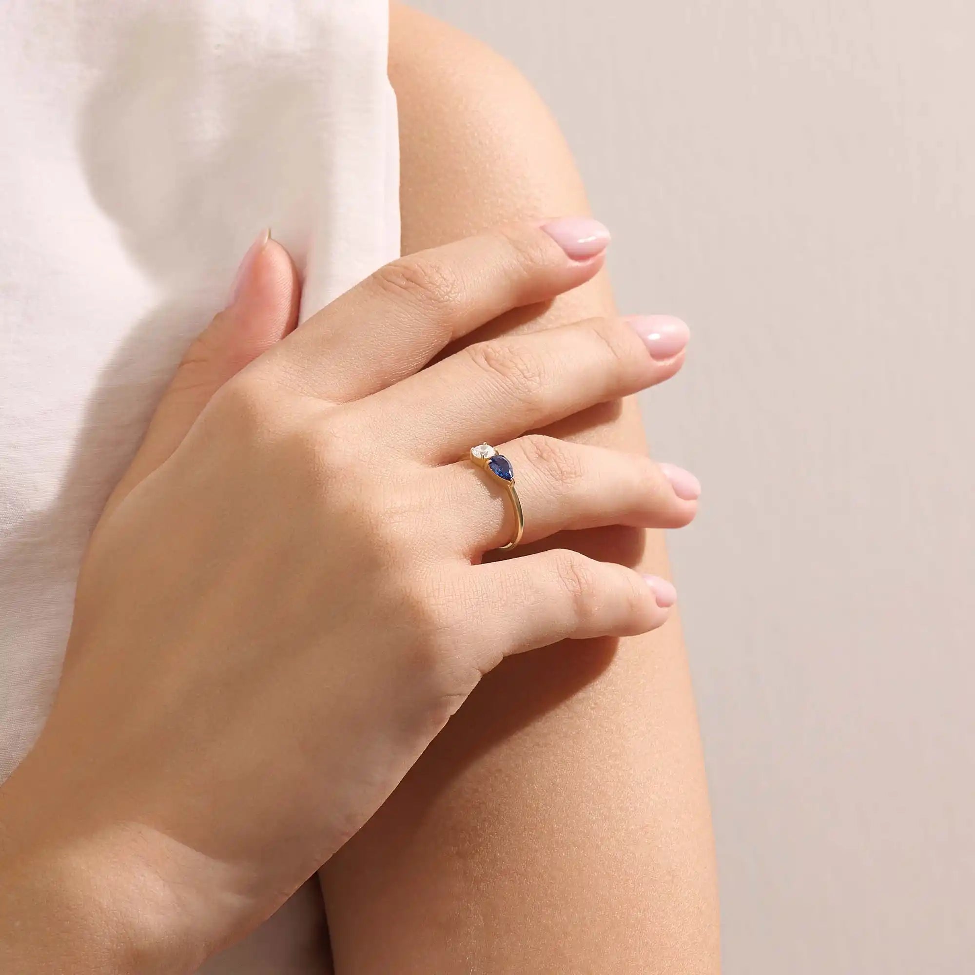 Model wearing a Toi et Moi sapphire and moissanite engagement ring. Unique gold ring symbolizing two souls, one love.