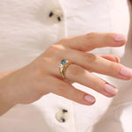 Model wearing a bold Toi et Moi ring with pear topaz and oval moissanite on a thick gold dome band.