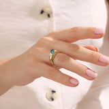 Model wearing a bold Toi et Moi ring with pear topaz and oval moissanite on a thick gold dome band.
