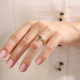 Model wearing a chunky 14k gold ring with half bezel set oval topaz. A statement gemstone ring with modern lines. Ideal for daily elegance or gifting.