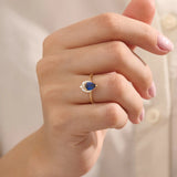 Model wearing a pear-shaped sapphire ring with moissanite accents in solid gold. A refined gemstone ring for special occasions or daily elegance.