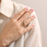 Model wearing a pear cut moss agate ring in 14k gold. A one-of-a-kind vintage anniversary ring with earthy elegance.
