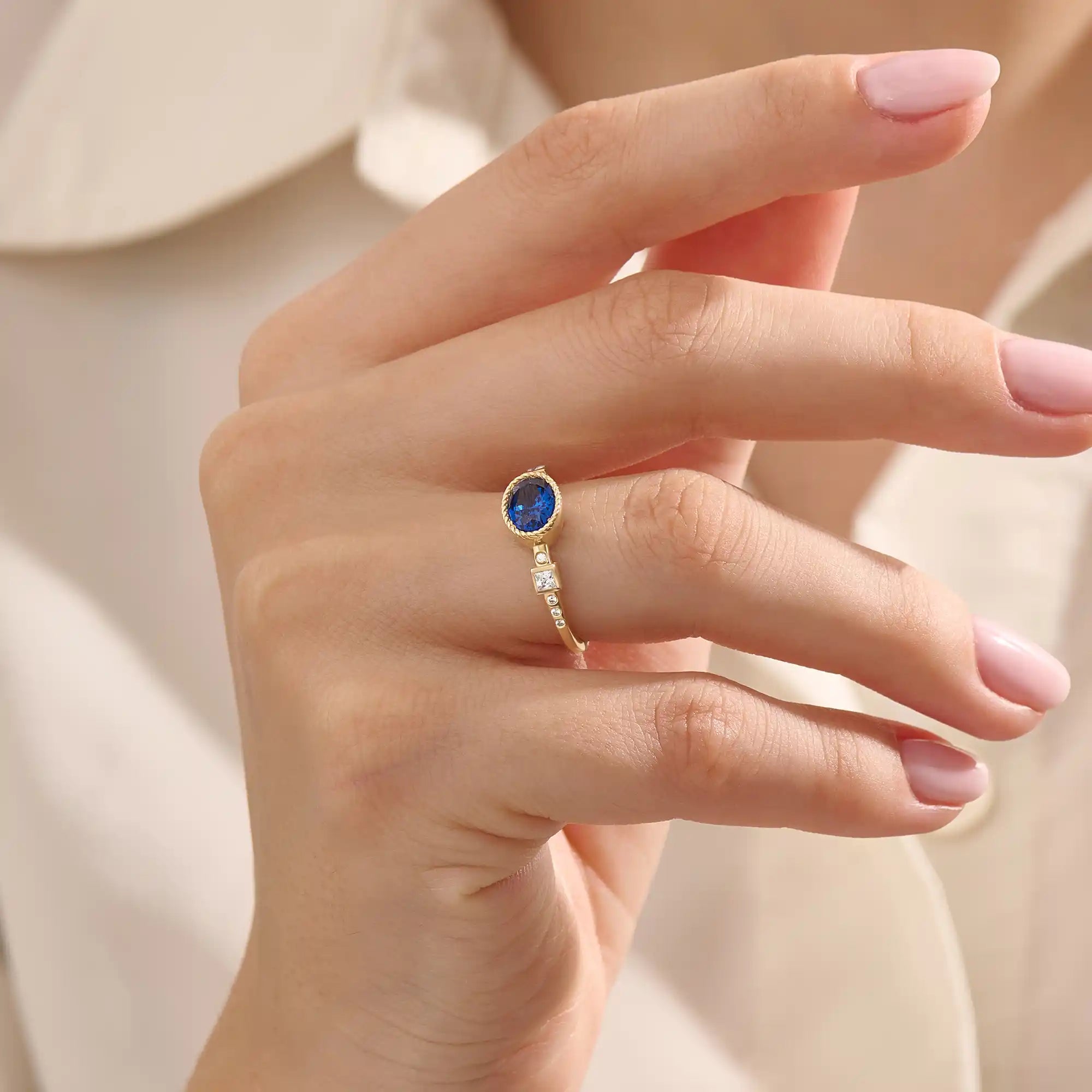Model wearing a vintage bezel set oval sapphire ring with moissanite accents. Elegant 14k gold solitaire gemstone ring for everyday or engagement.