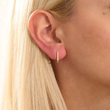 Model wearing minimalist U-shape hoop earrings in 14k gold, highlighting the sleek geometric design.