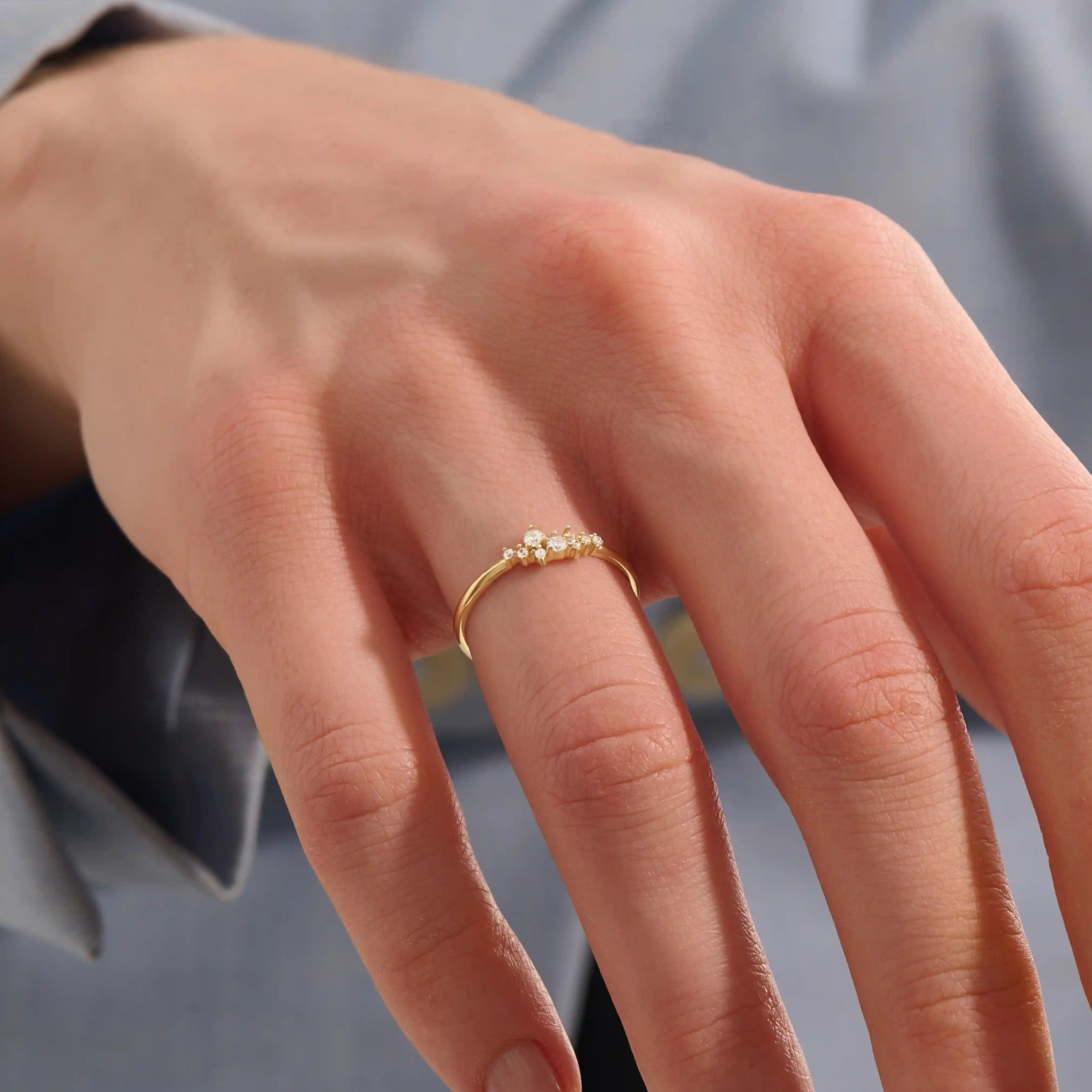 Model wearing minimalist cluster moissanite stacking wedding ring in 14k solid gold, showcasing a delicate round stone arrangement and sleek band design.