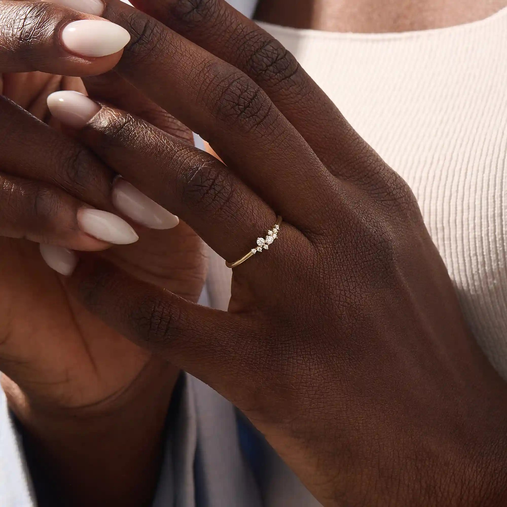 Model wearing minimalist cluster moissanite stacking wedding ring in 14k solid gold, showcasing a delicate round stone arrangement and sleek band design.