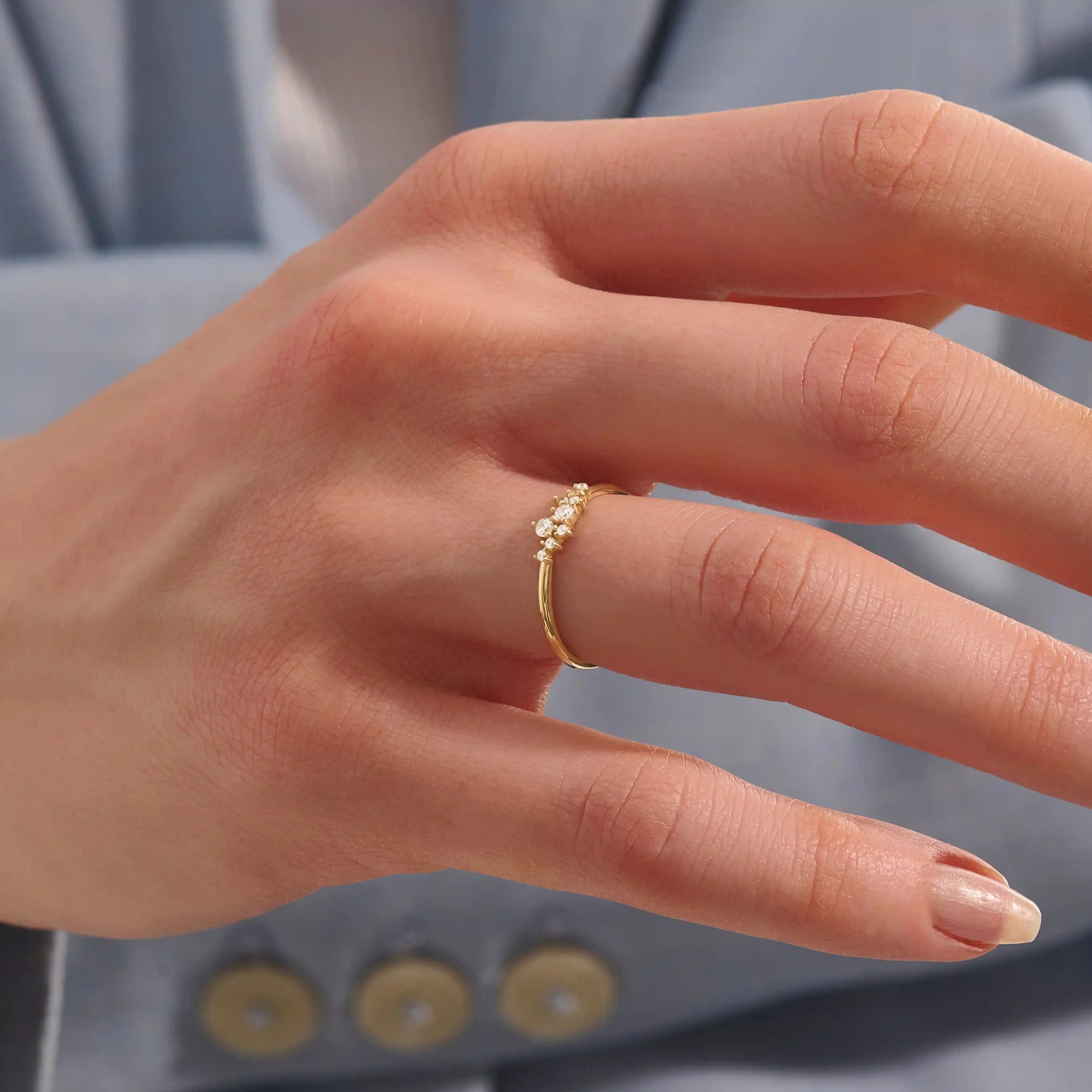 Model wearing minimalist cluster moissanite stacking wedding ring in 14k solid gold, showcasing a delicate round stone arrangement and sleek band design.