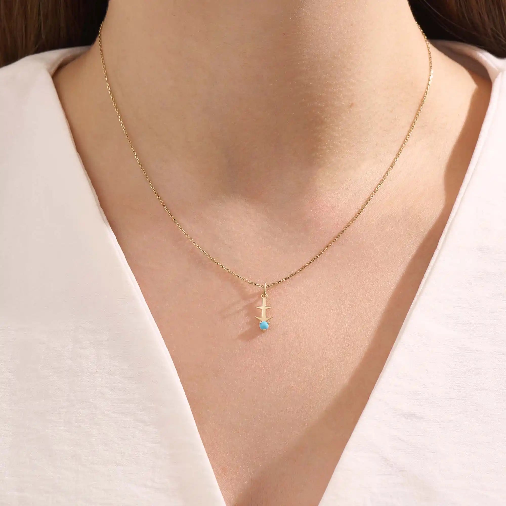 Model wears Sagittarius zodiac symbol pendant necklace in 14k solid gold with turquoise gemstone.