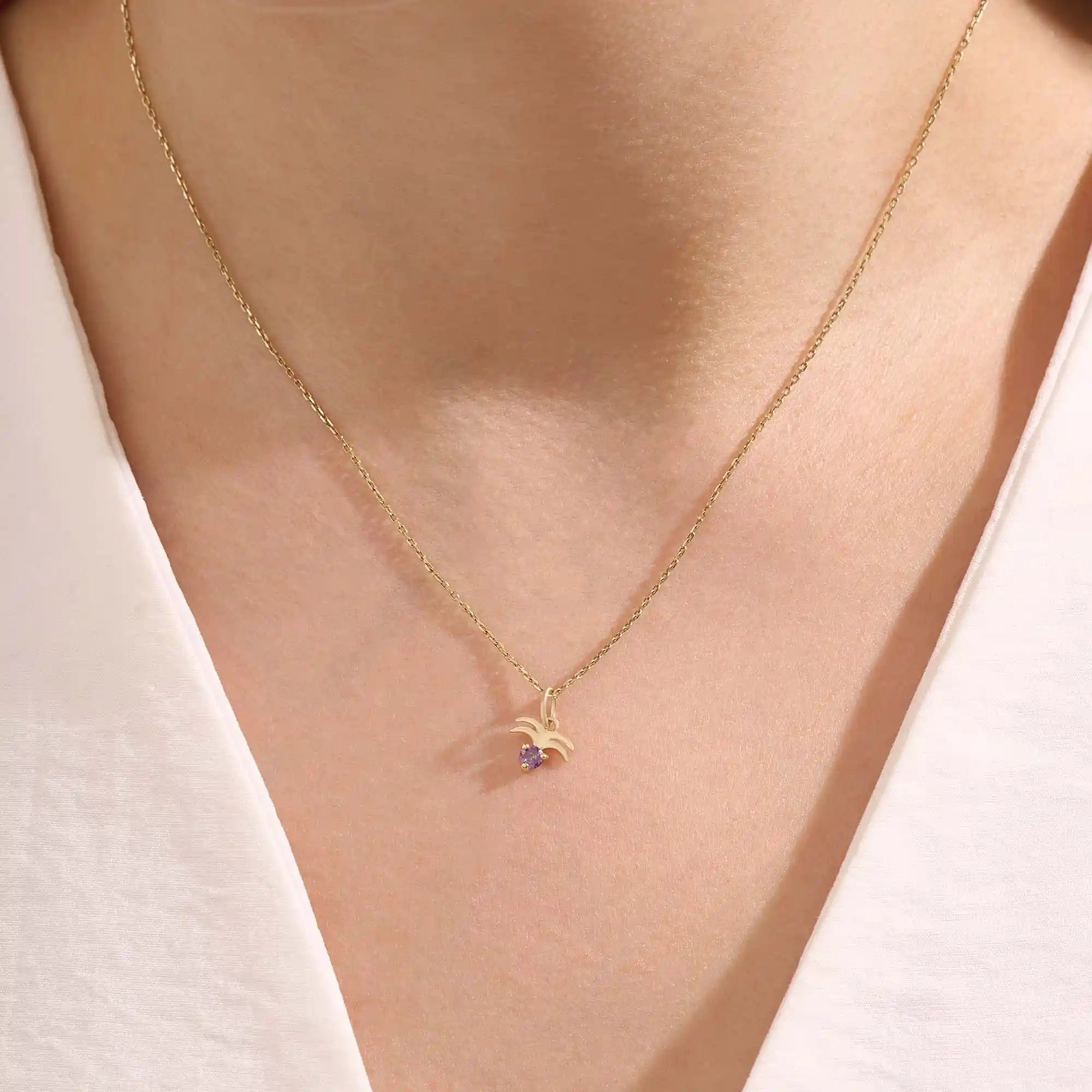 Model wears a 14k gold Aquarius zodiac pendant necklace featuring amethyst. Perfect for Aquarius zodiac birthdays and gifts.