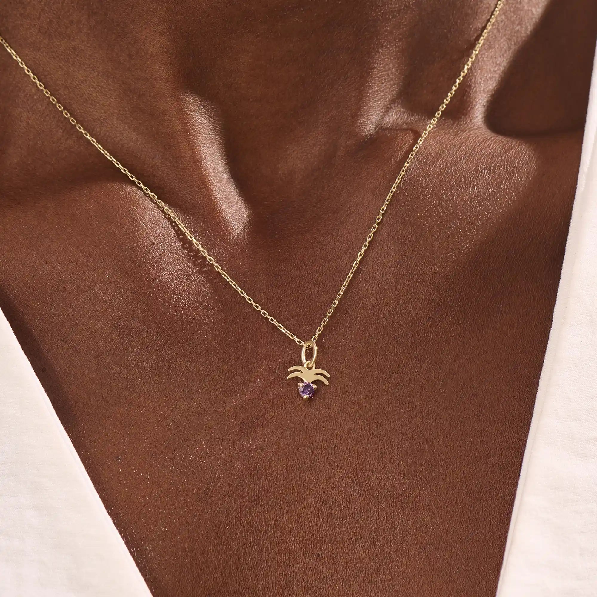 Model wears a 14k gold Aquarius zodiac pendant necklace featuring amethyst. Perfect for Aquarius zodiac birthdays and gifts.