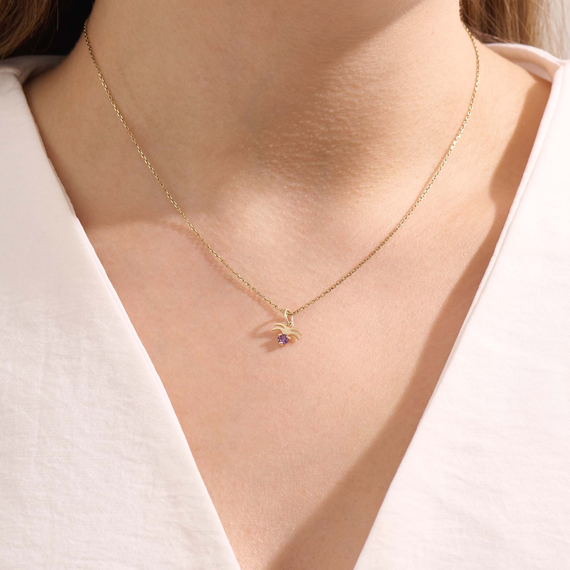 Model wears a 14k gold Aquarius zodiac pendant necklace featuring amethyst. Perfect for Aquarius zodiac birthdays and gifts.