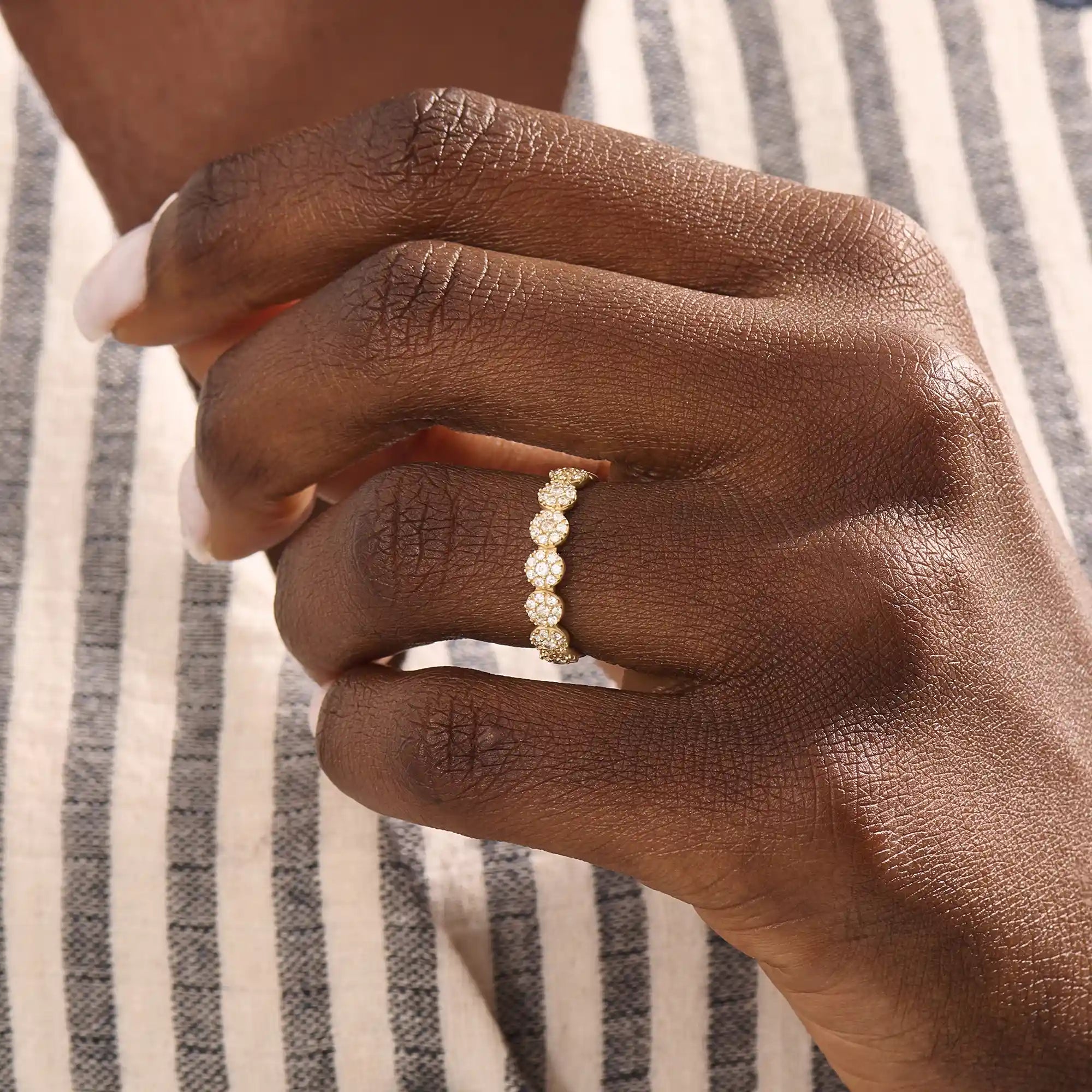 Model wears a 14k gold bold dots band ring with pave moissanites. Eye-catching statement piece for everyday style.