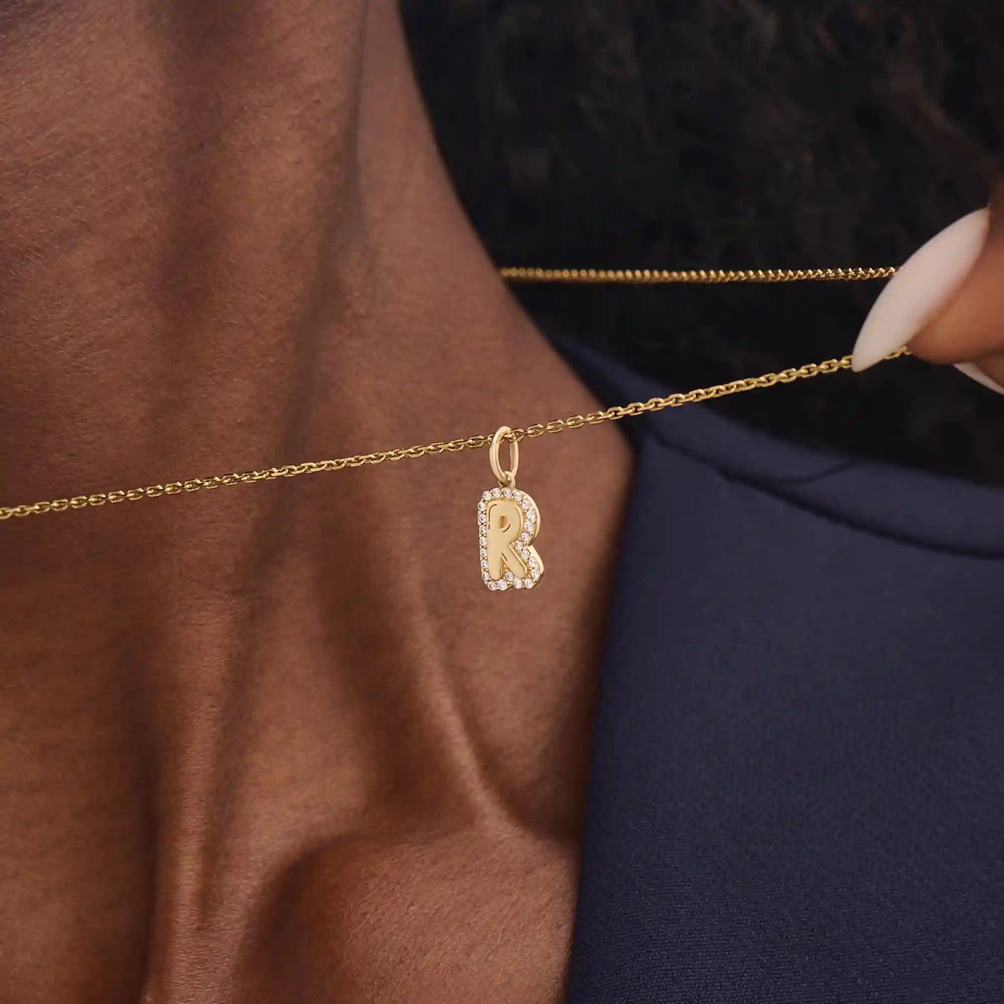 Model wears a 14k gold bubble initial necklace outlined with sparkling moissanites. Eye-catching and stylish, perfect for daily wear.