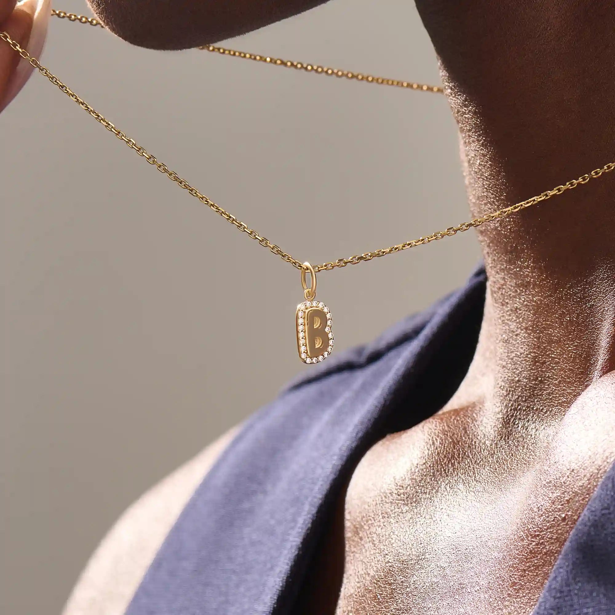 Model wears a 14k gold bubble initial necklace outlined with sparkling moissanites. Eye-catching and stylish, perfect for daily wear.