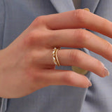 Model wears a 14k gold curved beaded ring adorned with round and marquise moissanites. An eye-catching stackable ring with elegant sparkle.