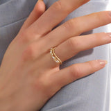 Model wears a 14k gold curved beaded ring adorned with round and marquise moissanites. An eye-catching stackable ring with elegant sparkle.