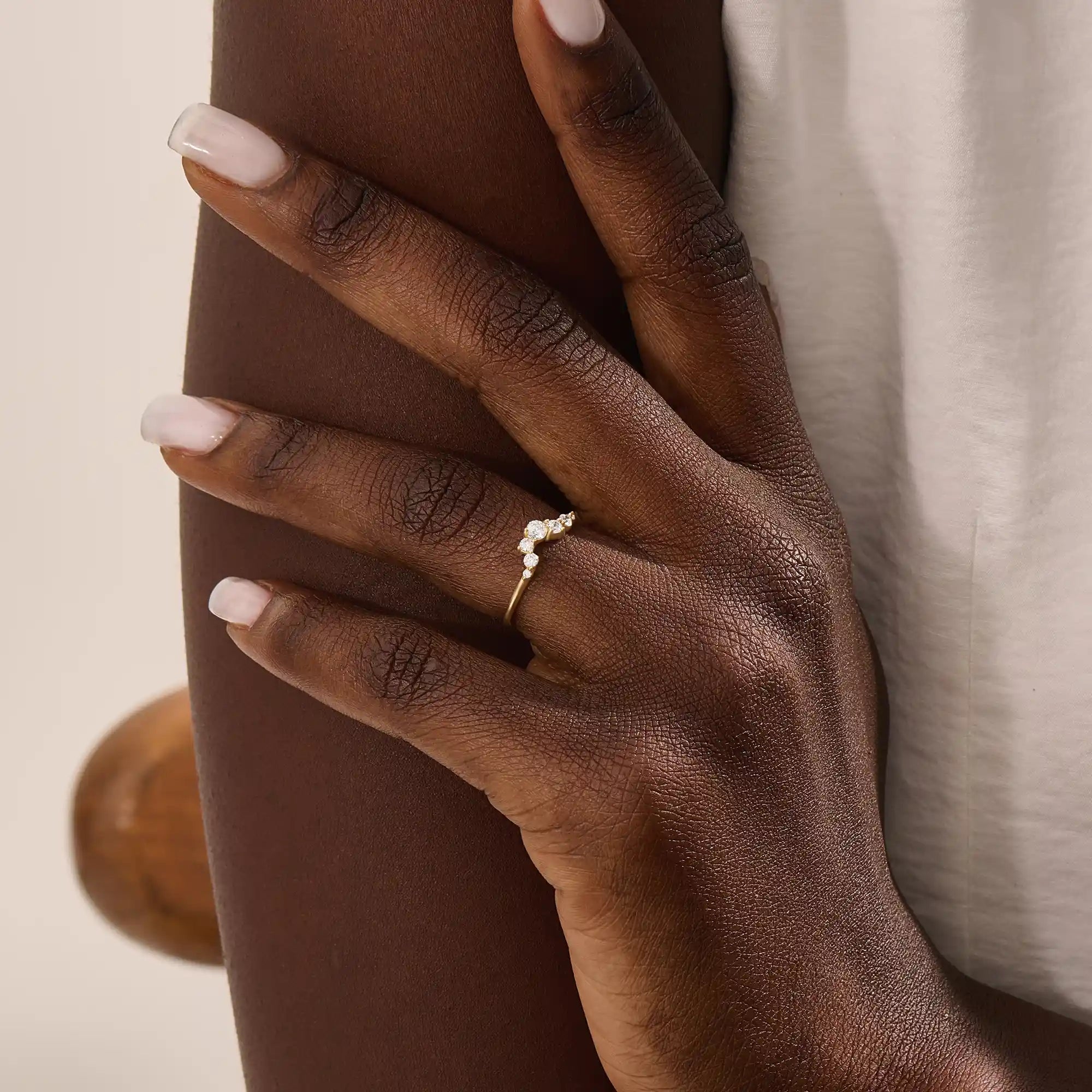 Model wears a 14k gold curved nesting ring adorned with clustered moissanites. Perfect for layering or wearing alone for subtle sparkle.