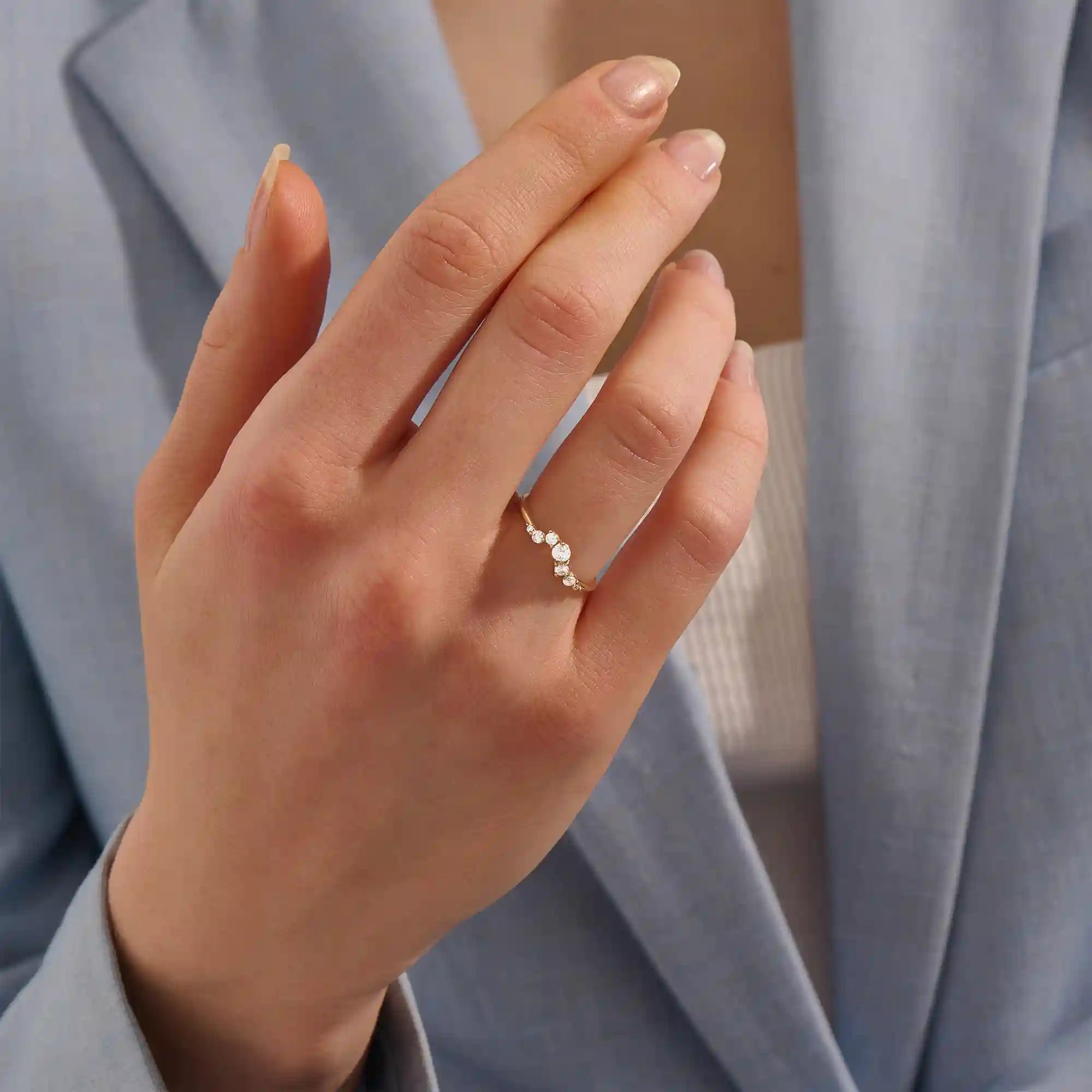 Model wears a 14k gold curved nesting ring adorned with clustered moissanites. Perfect for layering or wearing alone for subtle sparkle.