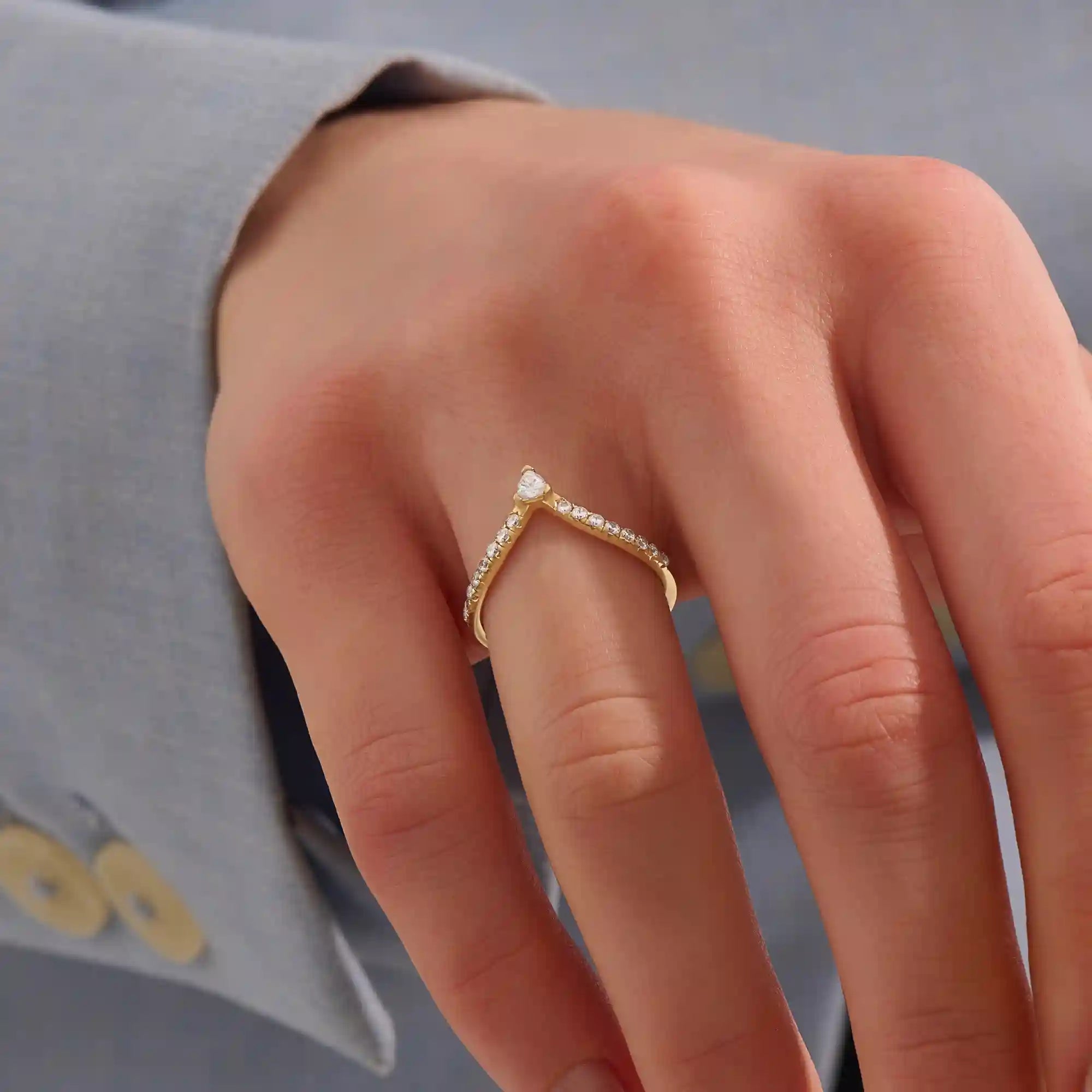 Model wears a 14k gold curved ring featuring a triangle moissanite centerpiece and pavé accents. Perfect for stacking with solitaires or bands.