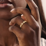 Model wears a 14k gold eternity statement ring featuring a beaded band and evil eye design. Stylish and meaningful everyday accessory.