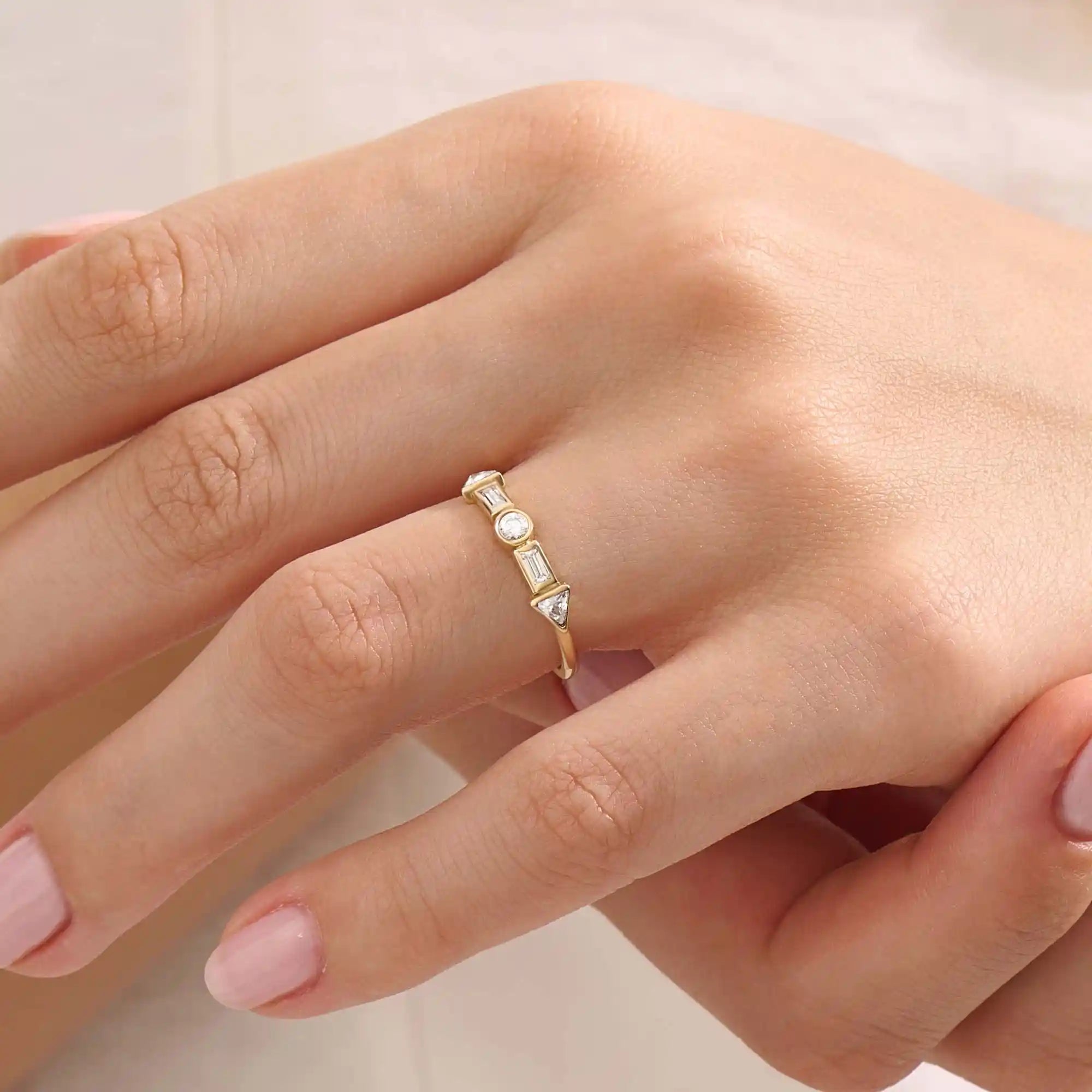 Model wears a 14k gold half eternity statement ring with bezel-set mixed cut stones. A bold and stylish piece for everyday wear.