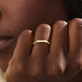 Model wears a 14k gold minimalist band ring with bezel moissanites around the band. Perfect everyday statement ring.