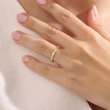 Model wears a 14k gold minimalist band ring with bezel moissanites around the band. Perfect everyday statement ring.