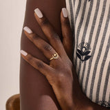 Model wears a 14k gold pinky signet ring adorned with moon and star engravings. A distinctive and stylish accessory for everyday wear.