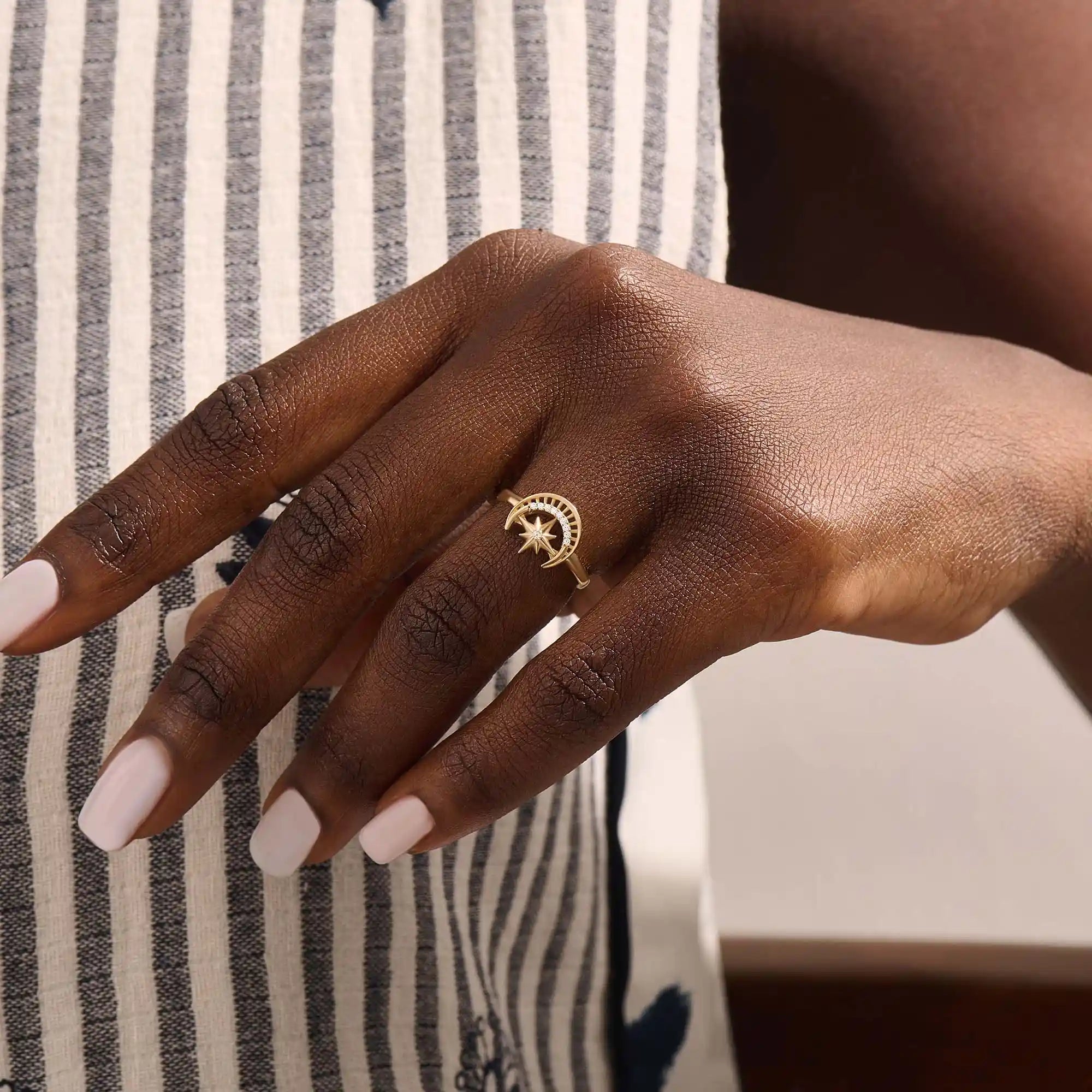 Model wears a 14k gold pinky signet ring adorned with moon and star engravings. A distinctive and stylish accessory for everyday wear.