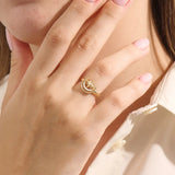 Model wears a 14k gold pinky signet ring adorned with moon and star engravings. A distinctive and stylish accessory for everyday wear.