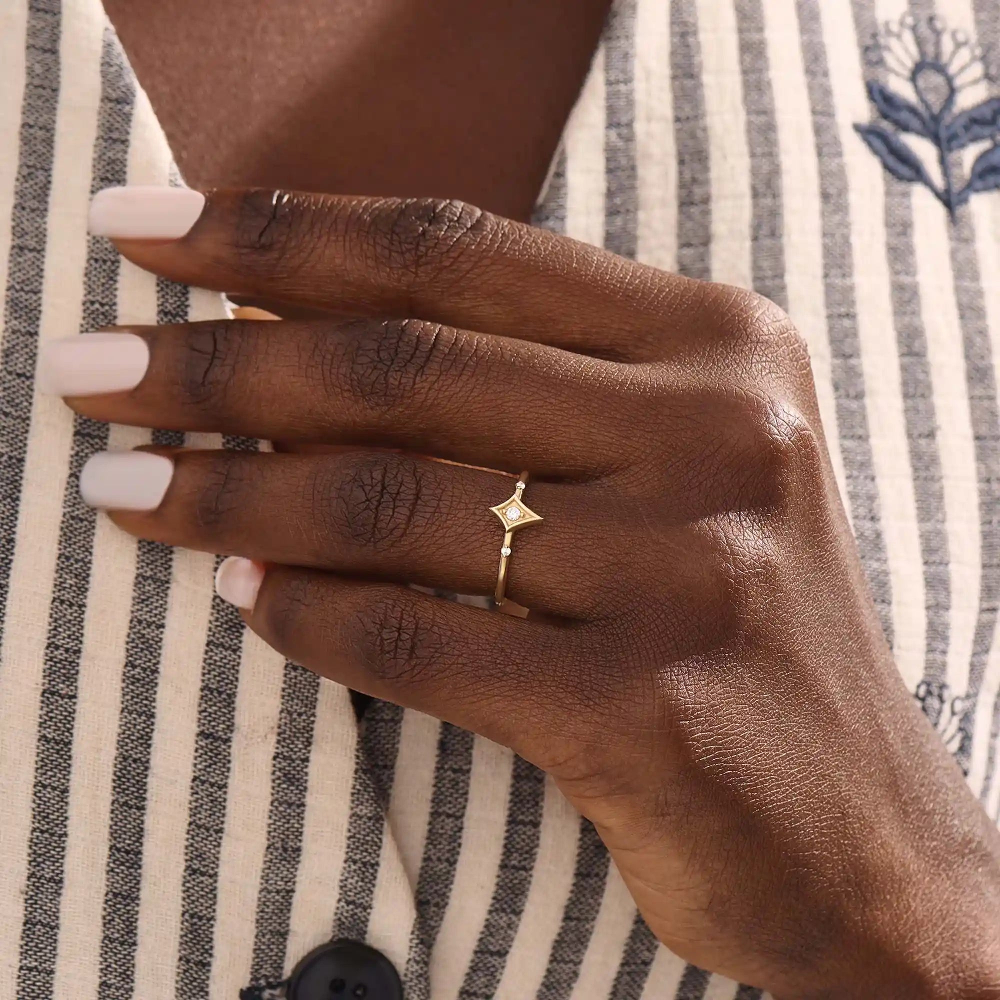 Model wears a 14k gold pinky signet ring featuring a sleek rhombus shape. A bold and stylish accessory for layering or solo use.