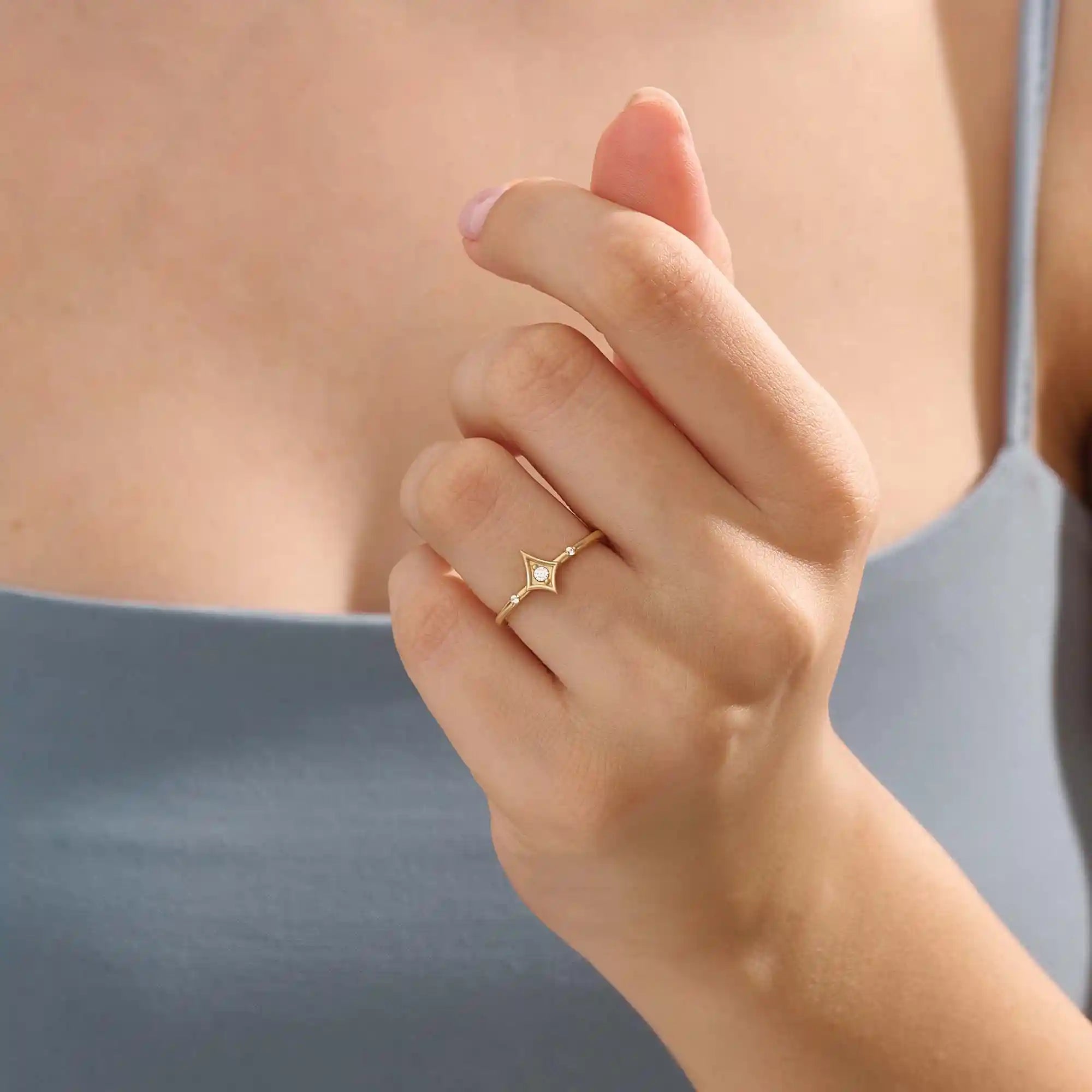 Model wears a 14k gold pinky signet ring featuring a sleek rhombus shape. A bold and stylish accessory for layering or solo use.