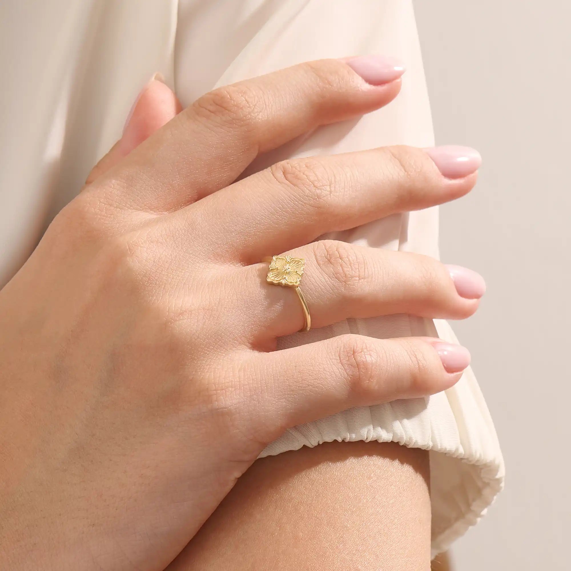 Model wears a 14k gold pinky signet ring with a clover motif. A stylish and delicate accessory perfect for layering or solo wear.