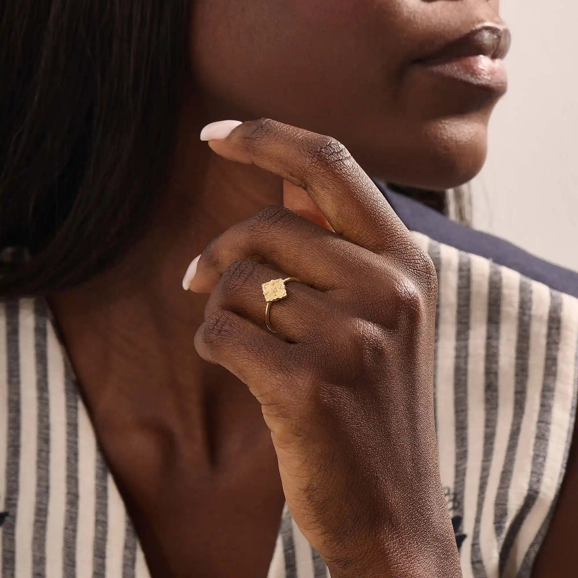 Model wears a 14k gold pinky signet ring with a clover motif. A stylish and delicate accessory perfect for layering or solo wear.