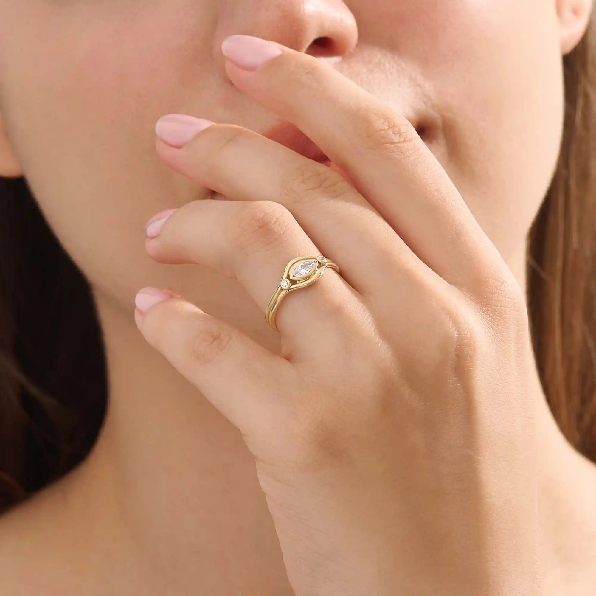 Model wears a 14k gold pinky signet ring with a marquise moissanite bezel-set evil eye motif. A unique and meaningful accessory for everyday wear.