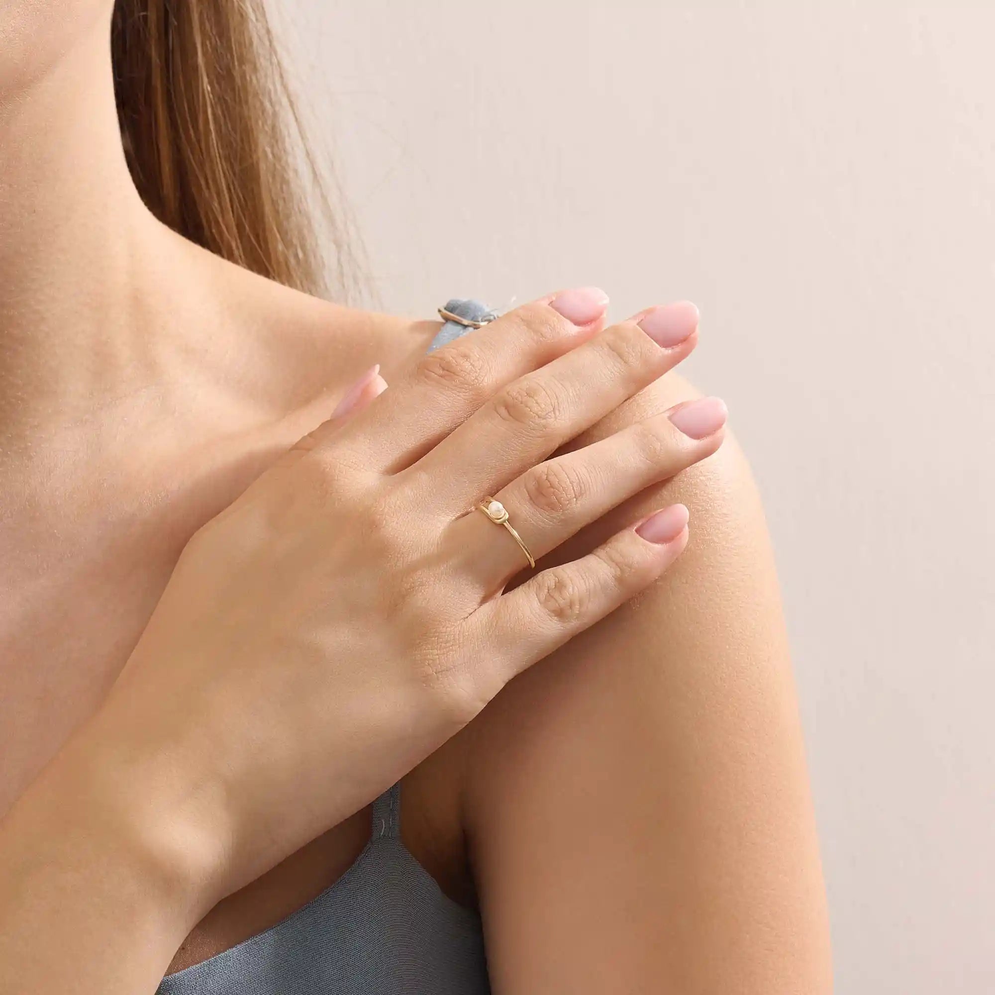 Model wears a 14k gold split band promise ring with a solo pearl centerpiece. A sleek and timeless piece ideal for layering or gifting.
