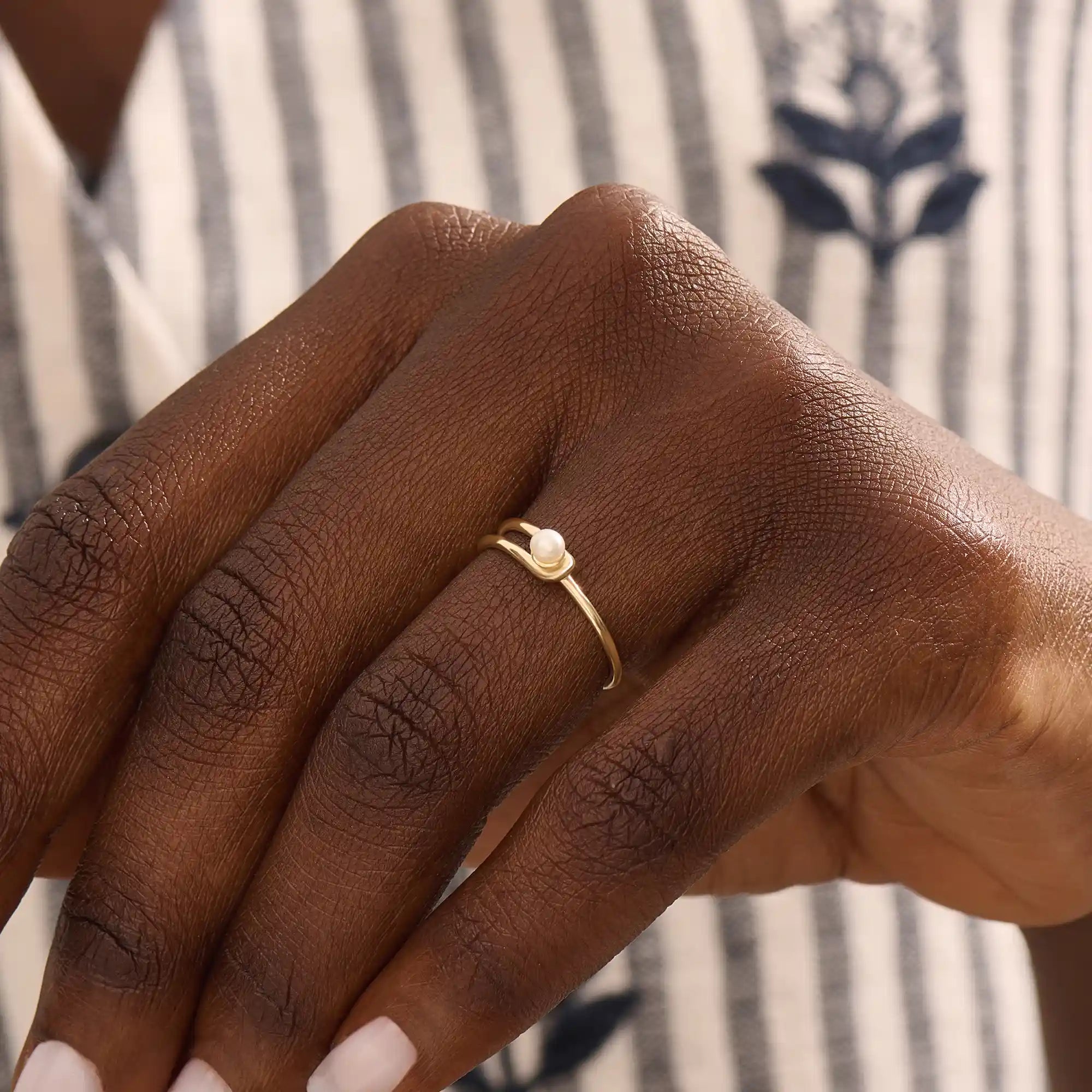 Model wears a 14k gold split band promise ring with a solo pearl centerpiece. A sleek and timeless piece ideal for layering or gifting.