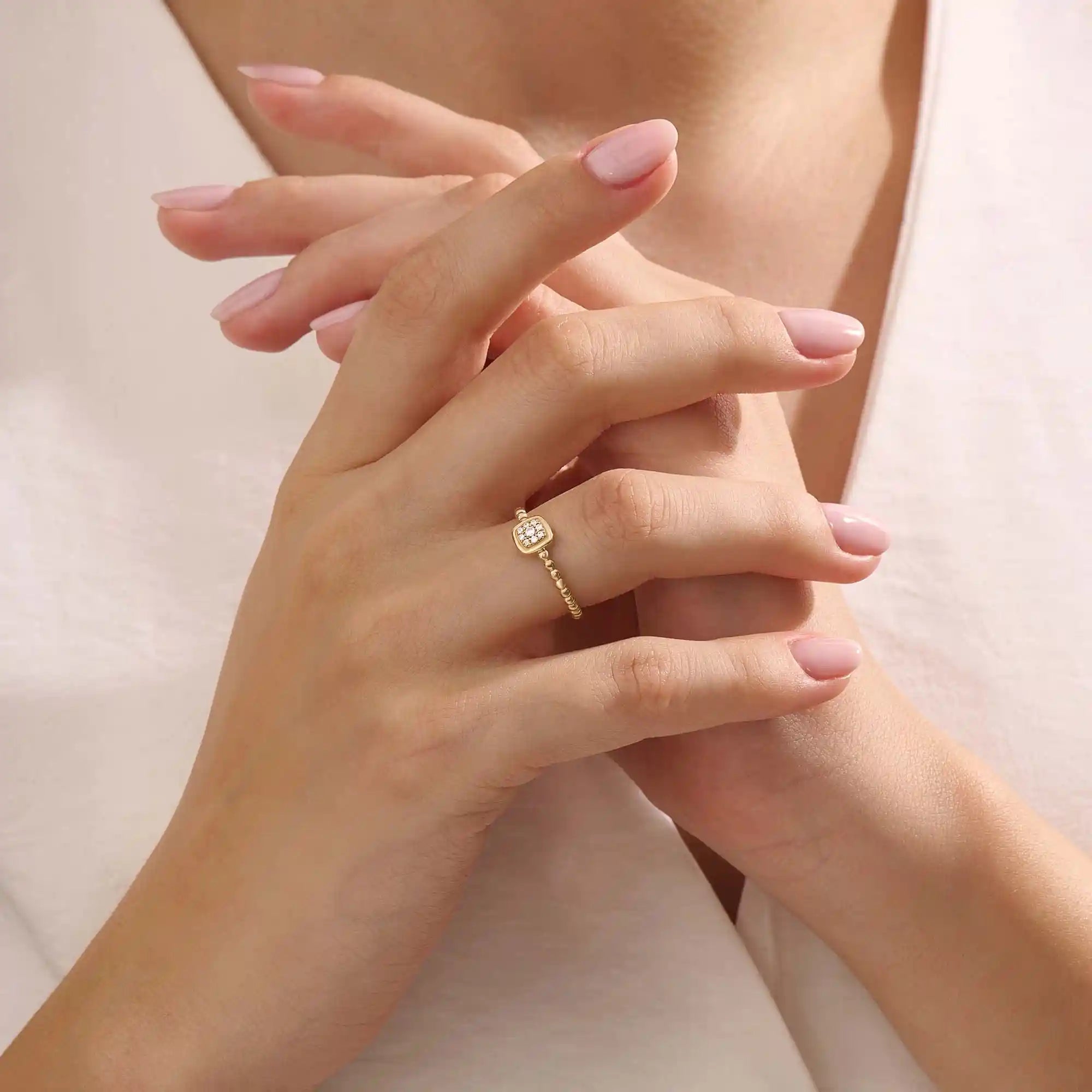 Model wears a 14k gold square pinky signet ring featuring a detailed beaded band. A sleek accessory perfect for layering or solo wear.
