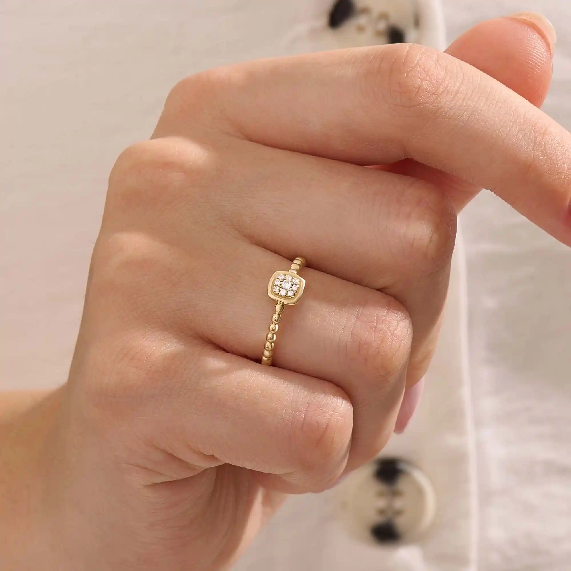 Model wears a 14k gold square pinky signet ring featuring a detailed beaded band. A sleek accessory perfect for layering or solo wear.