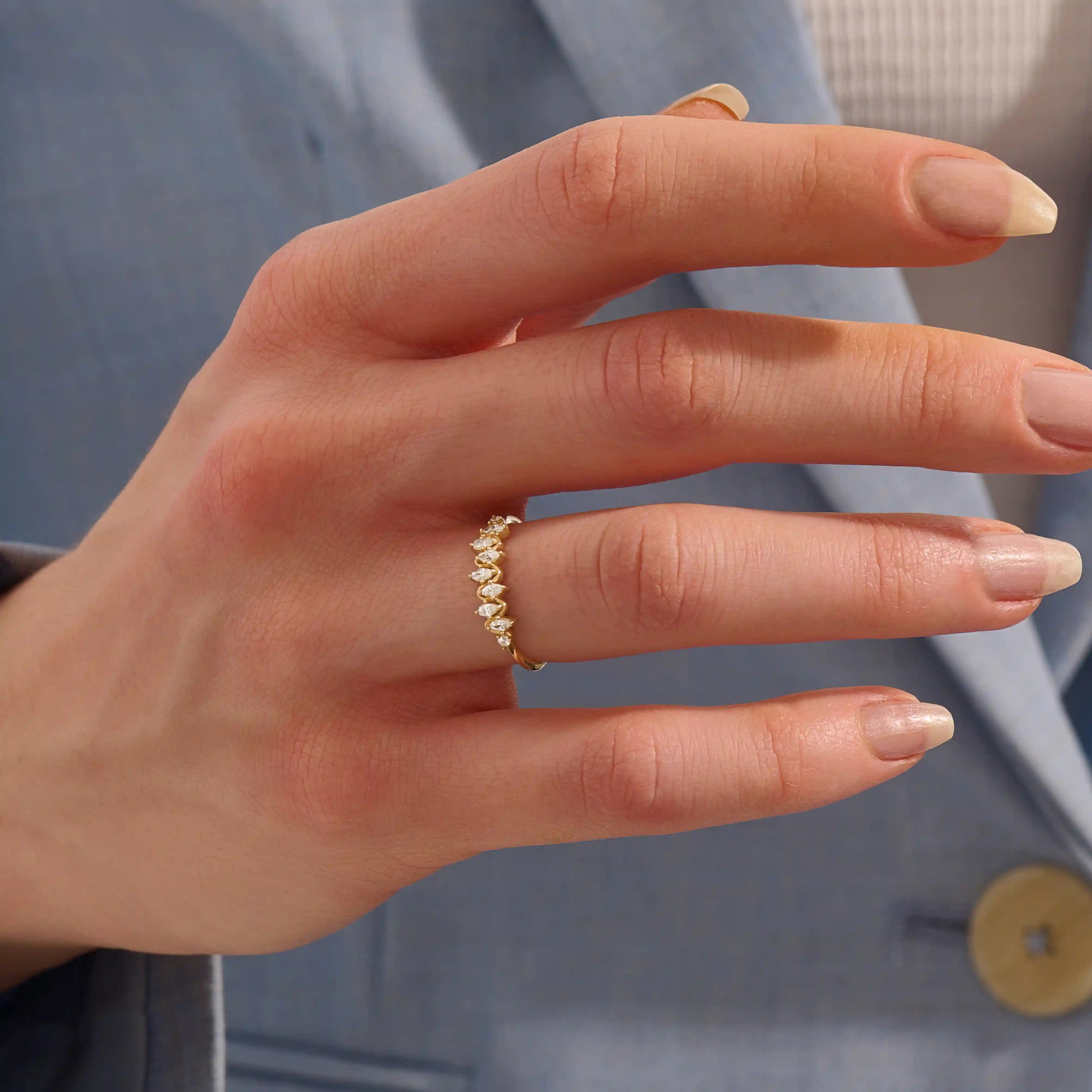 Model wears a 14k gold stacking ring featuring pavé marquise stones in an alternating ups and downs pattern. Perfect for layering with other rings.
