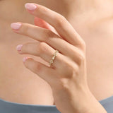 Model wears a 14k gold statement ring with a leaf motif and moissanite accent. Elegant and versatile everyday accessory.