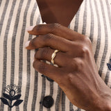 Model wears a 14k gold twisted band eternity ring featuring moissanite accents. A stylish and timeless statement piece for everyday wear.