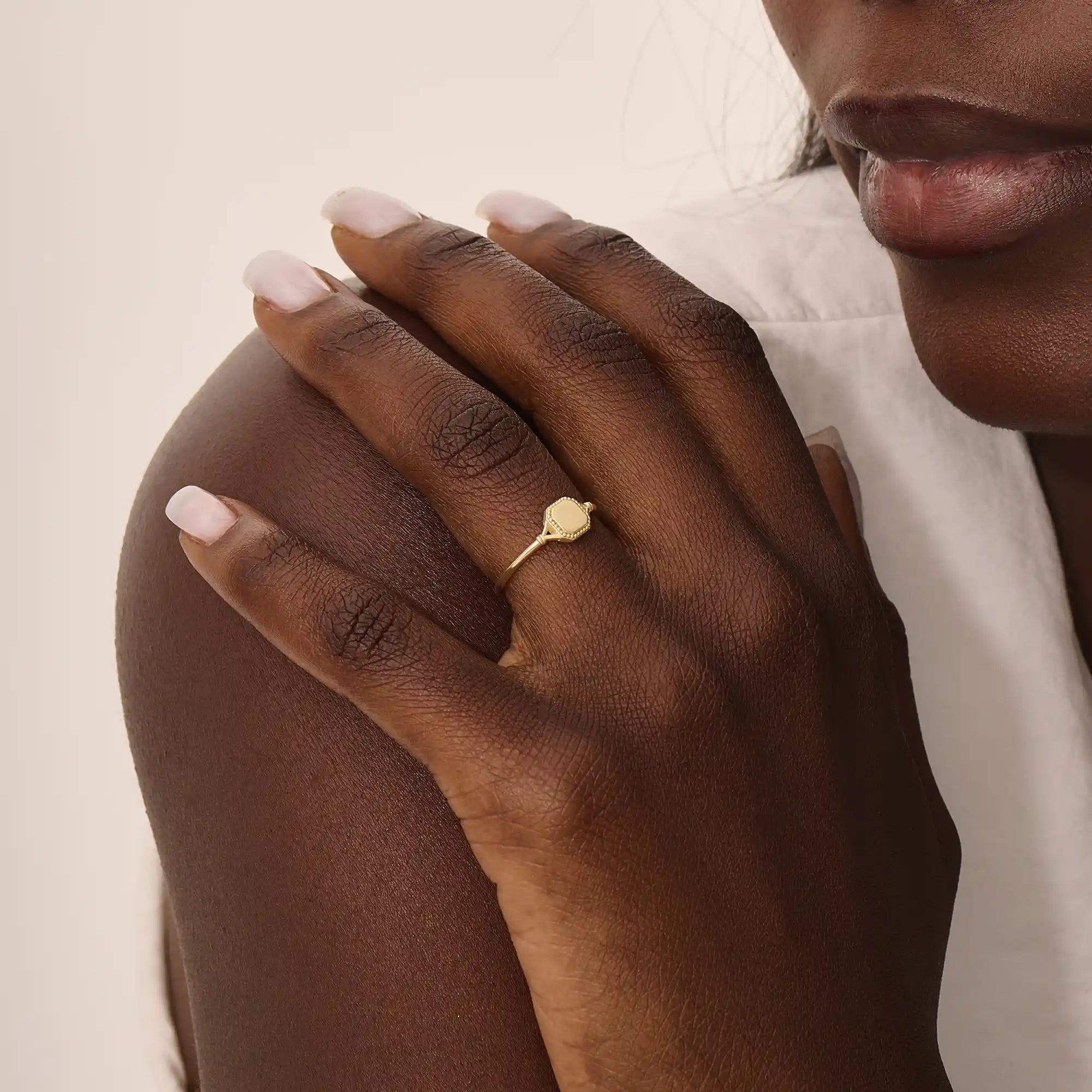 Model wears a 14k gold vintage square signet ring featuring intricate design elements. A bold and refined accessory for modern style.