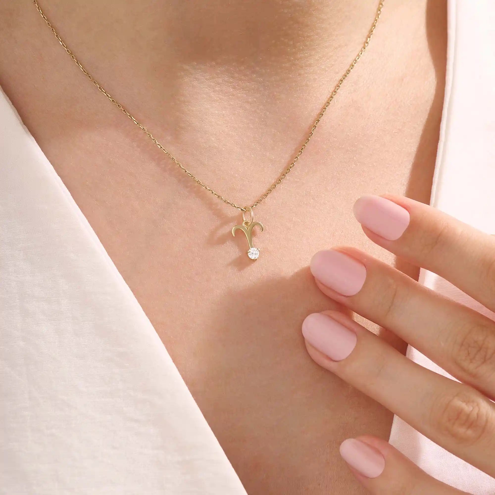 Model wears a 14k solid gold Aries zodiac symbol pendant necklace with clear moissanite, perfect for Aries astrology lovers.