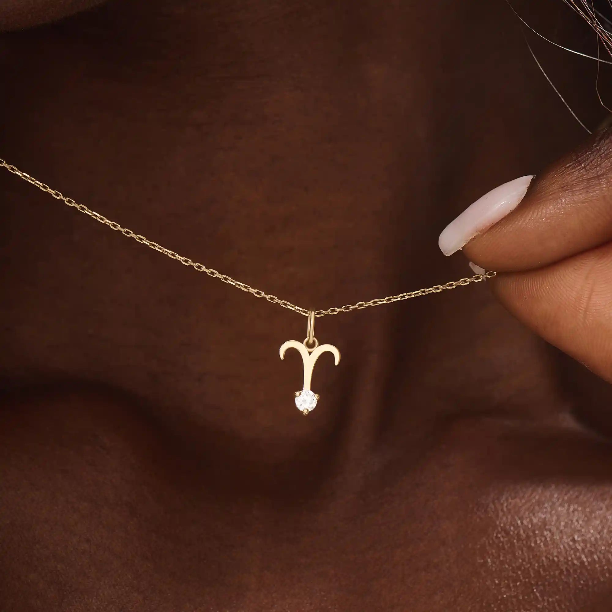 Model wears a 14k solid gold Aries zodiac symbol pendant necklace with clear moissanite, perfect for Aries astrology lovers.
